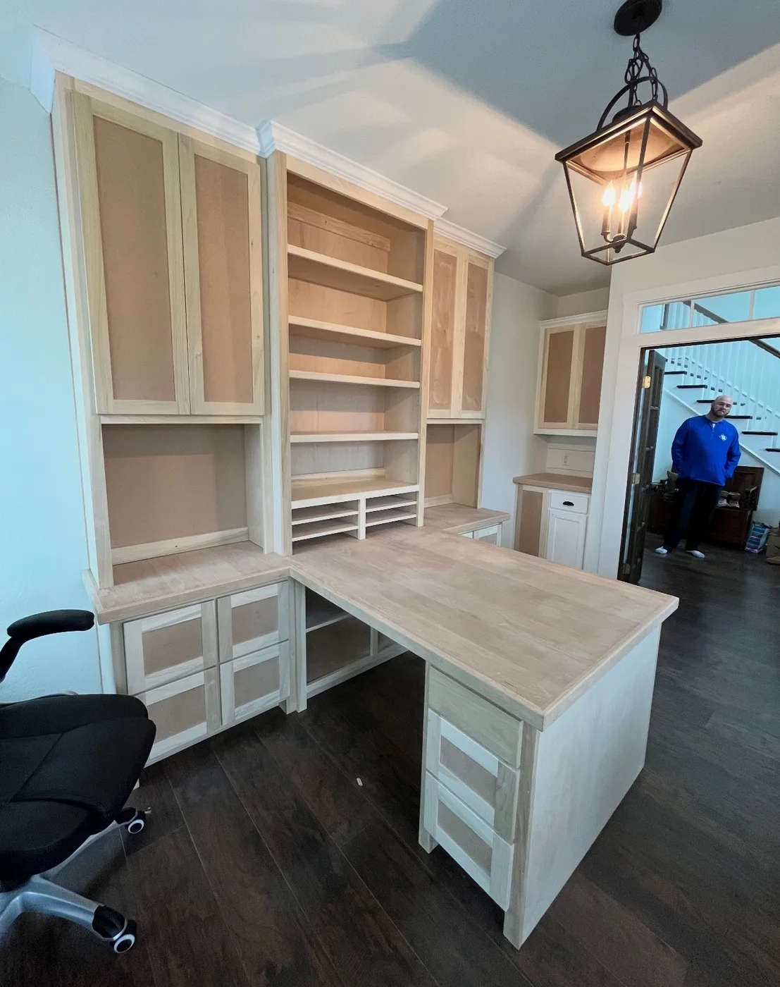 Custom home office with an L-shaped desk, drawers and open shelving